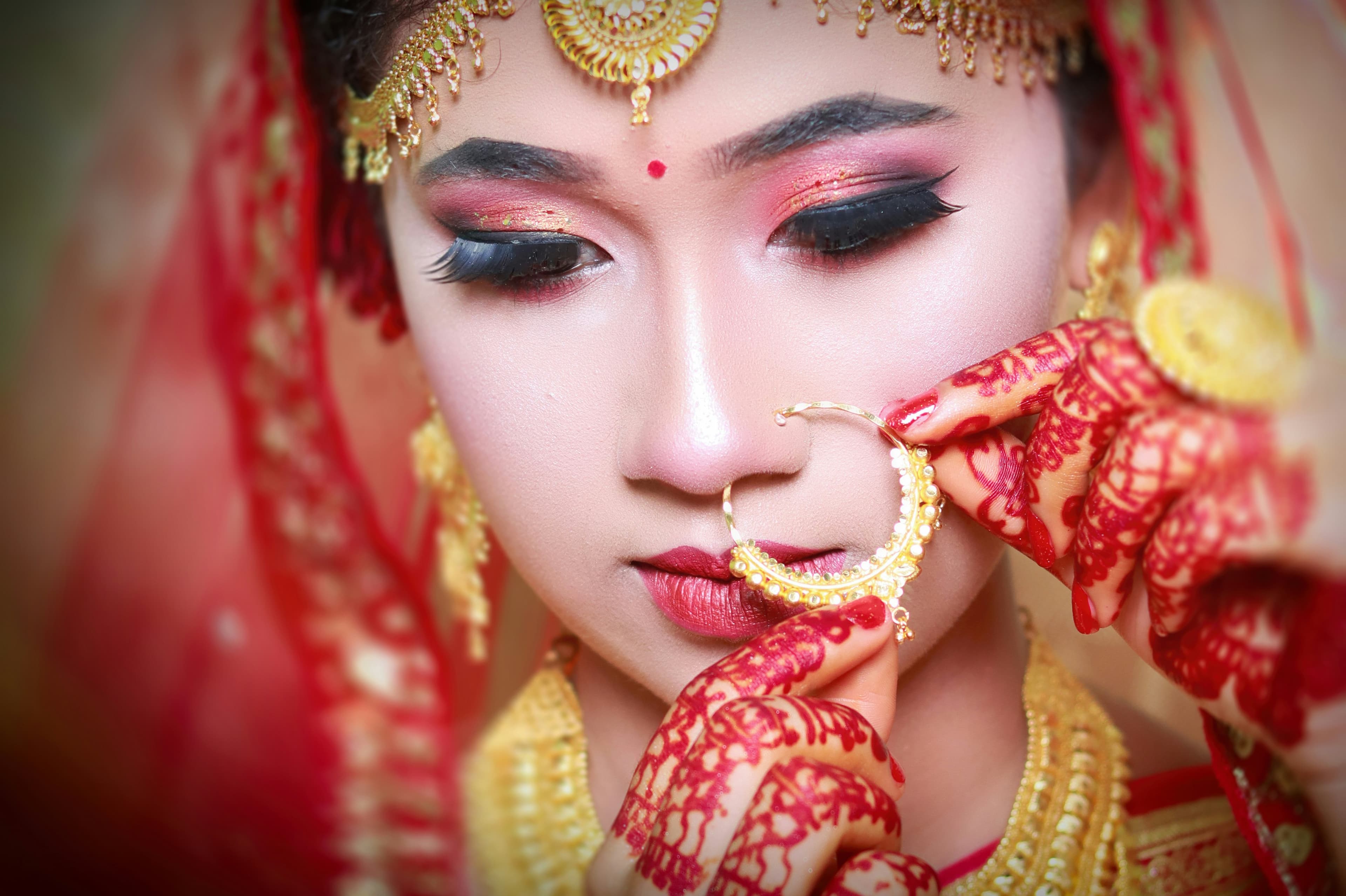 A bride and groom in a tender pose, surrounded by greenery.