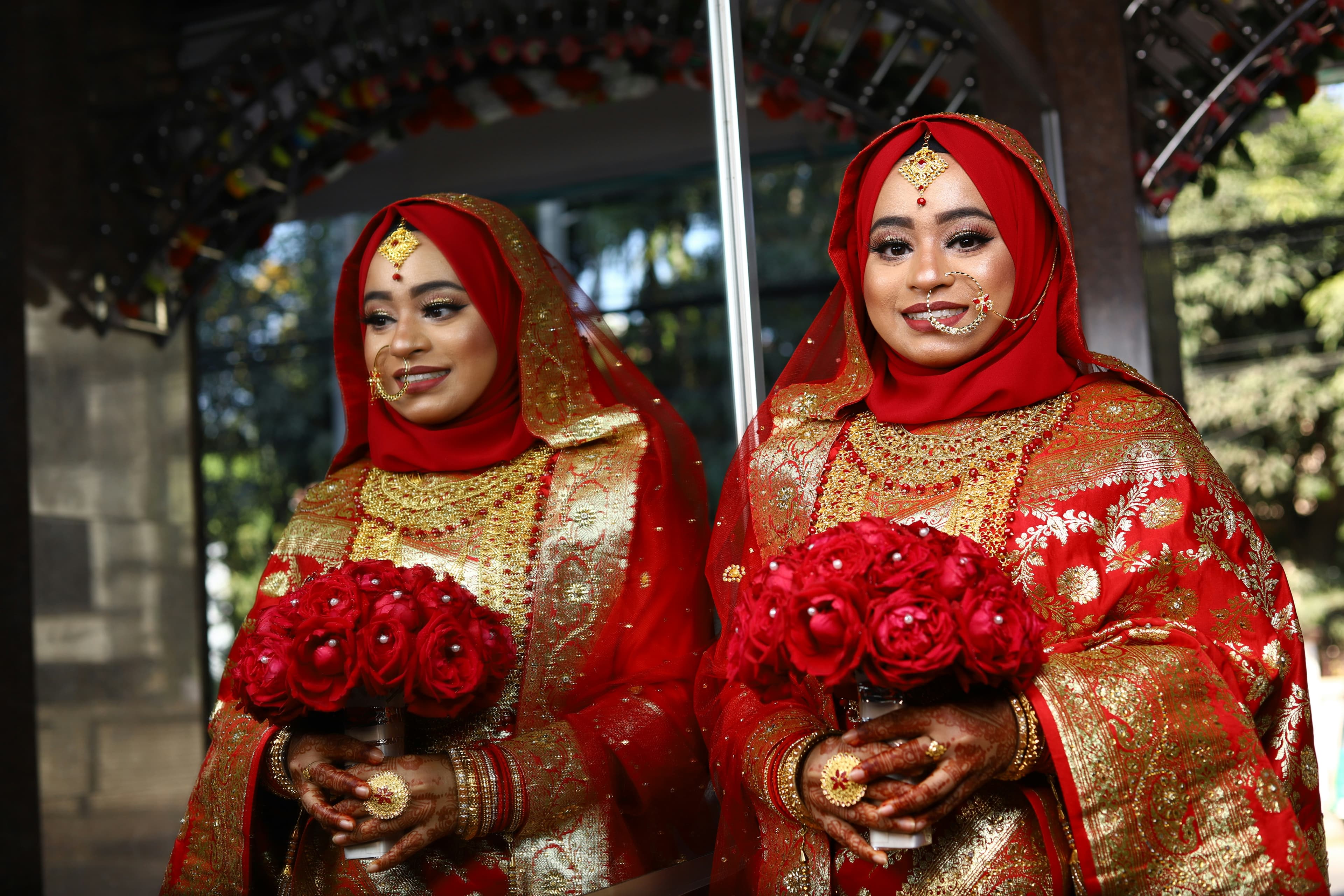 A bride in a beautiful white and red saree, posing elegantly.